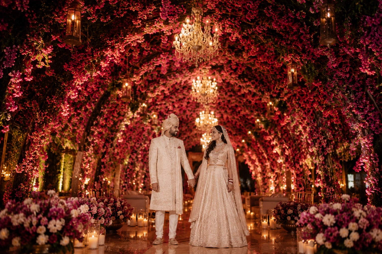 Luxury bougainvillea floral ceiling tunnel in Udaipur featuring cascading pink blossoms, crystal chandeliers, and an immersive floral walkway designed for an elegant Indian destination wedding celebration.