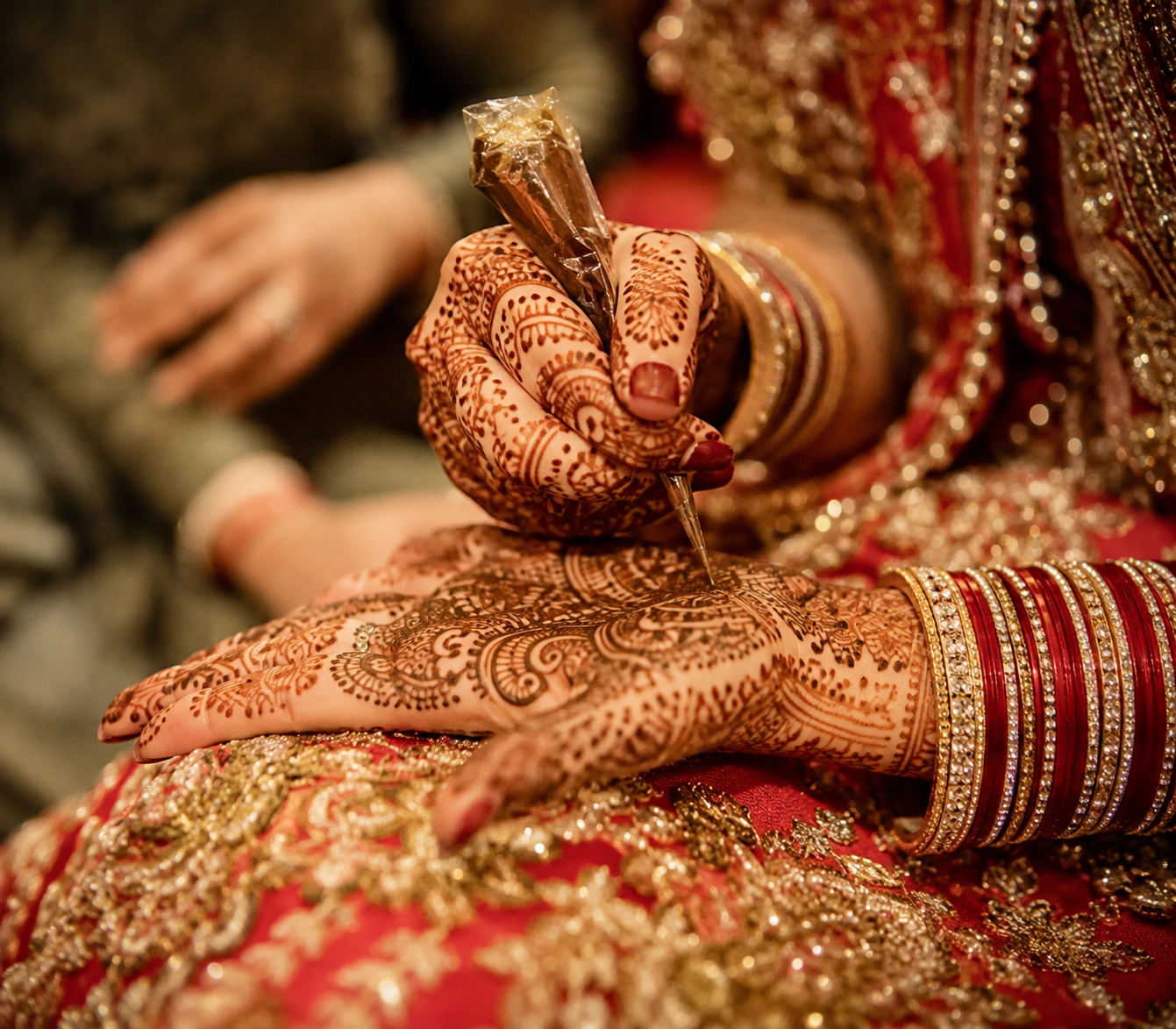 Close-up of intricate bridal Mehendi hands with detailed henna artistry during a traditional Indian wedding ceremony, photographed in a candid luxury wedding style by Lotus Grandeure.